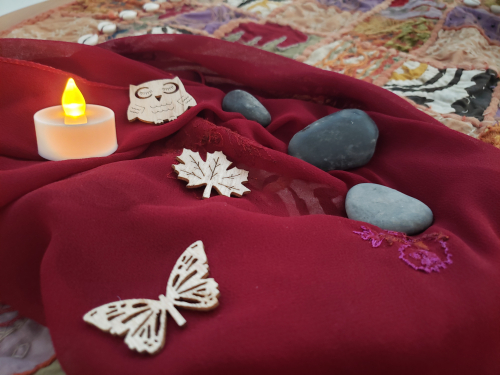 Electric tea light, stones and wooden ornaments on a decorative cloth