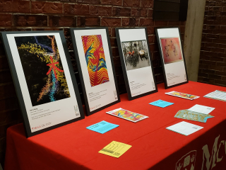 Photo of 4 art pieces on a table display at Mac campus