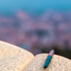 writing in a journal in front of a blurry landscape