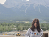 Student outside, in front of a mountain
