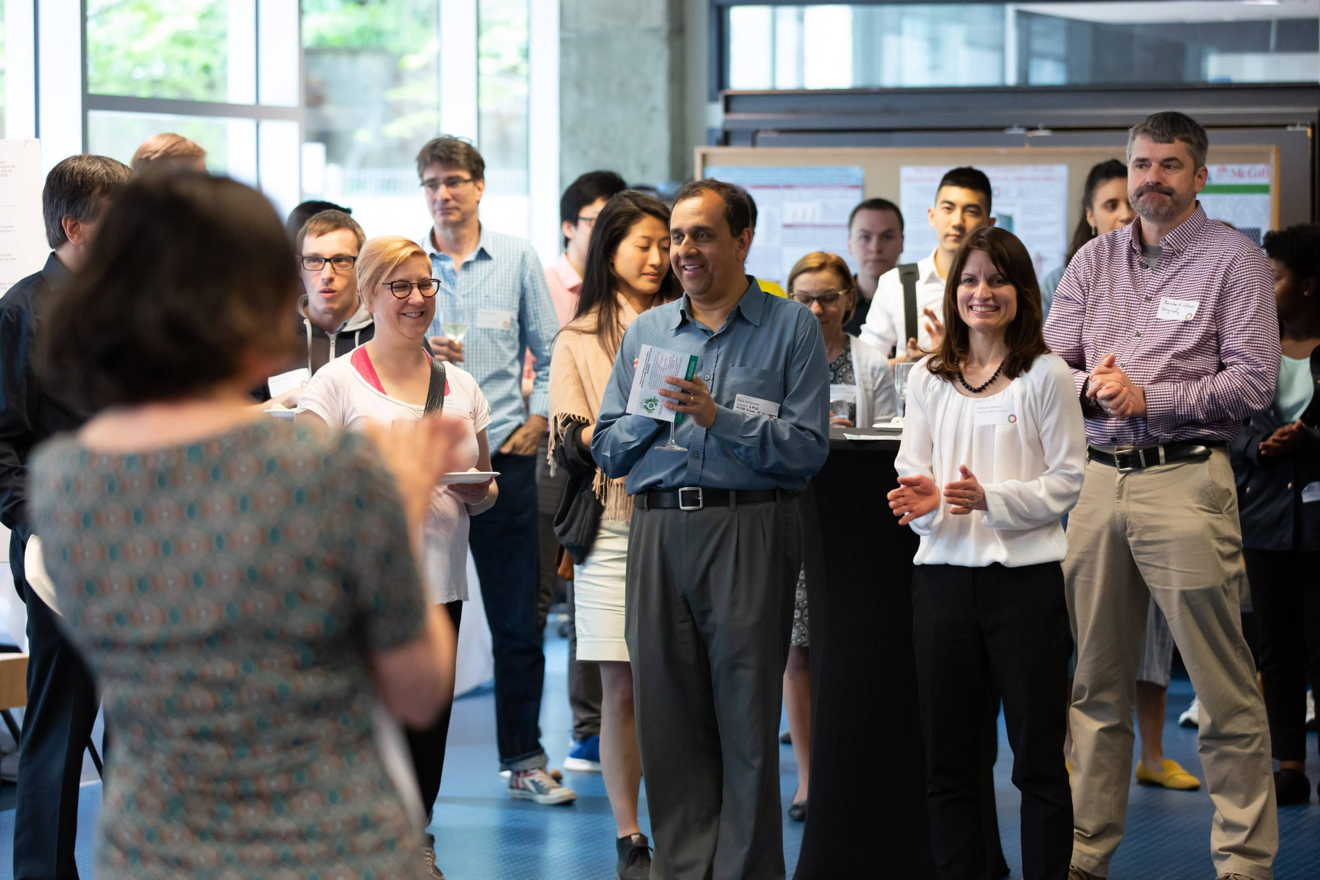 McGill faculty members listen as MSSI Program Director Heather McShane announces fund recipients at a sunny cocktail reception
