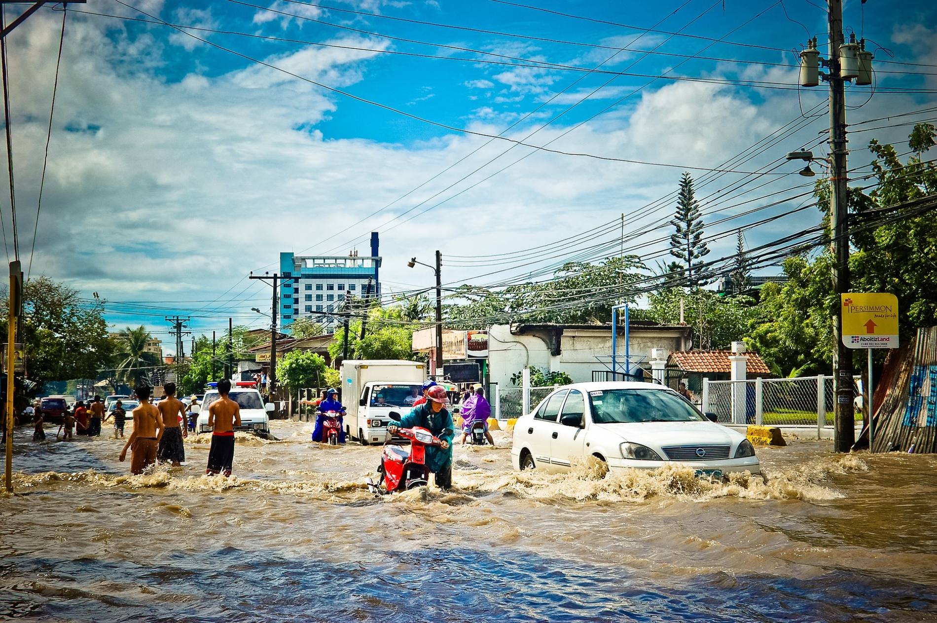 People and cars in a flooded street.