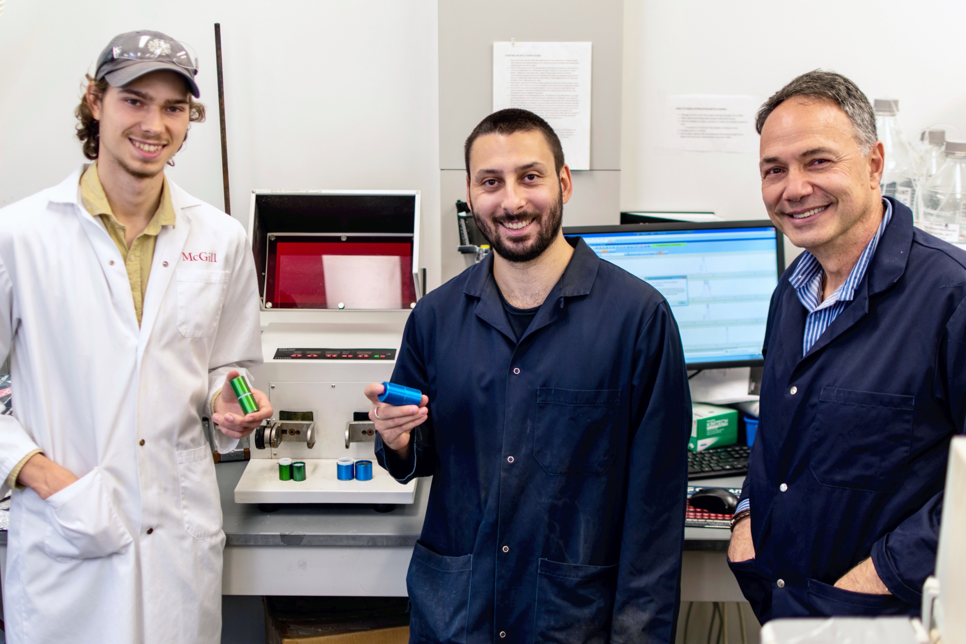 PhD students Julian Marlyn and James Thorpe, along with Prof. Masad Damha pose in a lab in front of a vibration ball mill.