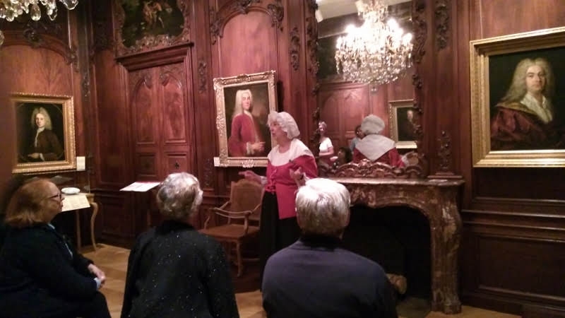 members listening to the guide inside the Chateau Ramezay