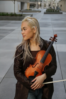 Photo of Astrid Nakamura holding a violin