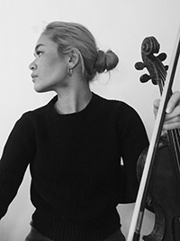 Photo of Astrid Nakamura holding bow and instrument 