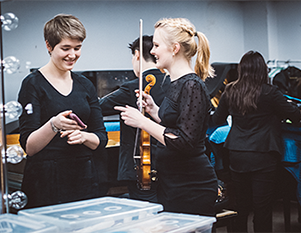 Students holding instruments and cell phone