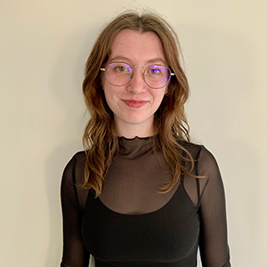 Headshot of woman wearing glasses and smiling slightly while looking at the camera