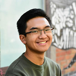 Man wearing glasses smiles at camera