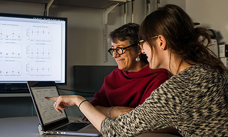 two women in discussion while looking at a computer monitor