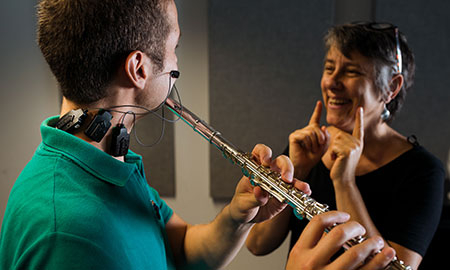 Professor demonstrates proper technique to flute student