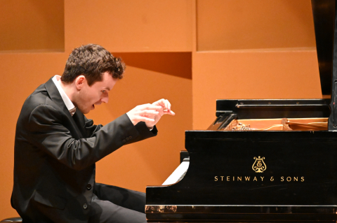 Alexey Shafirov playing piano with a happy look on his face