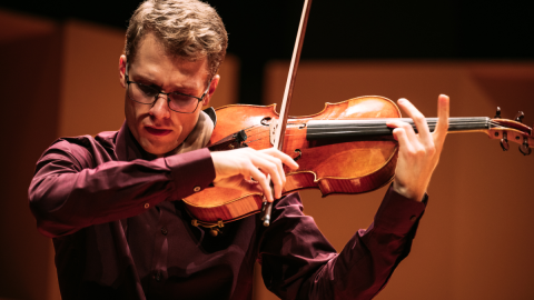 David Montreuil playing his viola on stage at the 2023-2024 Golden Violin Award competition