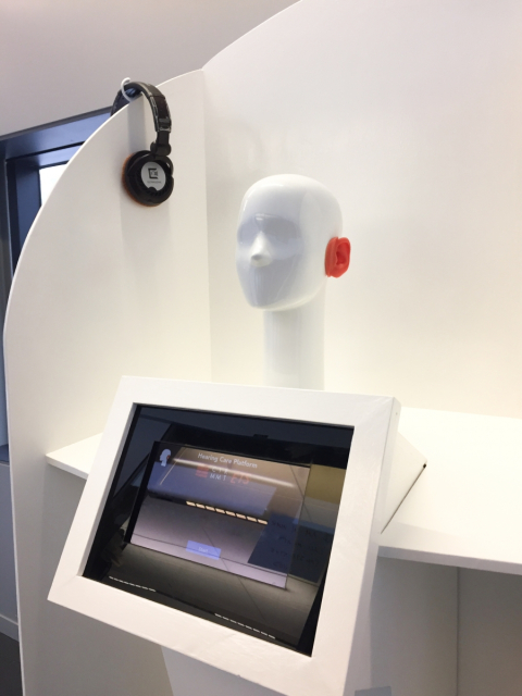 A white mannequin head with orange silicon ears used to test noise levels.
