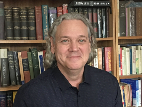 Jerry M. Cain standing in front of a book case