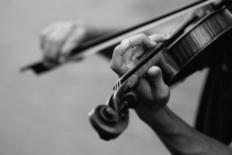Black and white image of a person playing a violin