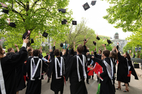 Graduates throwing this caps in the air outside McGill's convocation tent