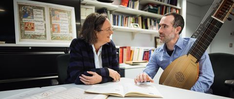 woman smiling as she speak with man while sitting at a desk