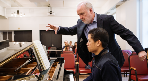 Michael McMahon oversees student on piano