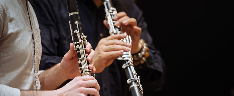 Two sets of hands holding clarinets