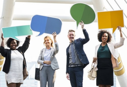 Four people holding up cardboards with various shapes