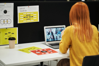 A woman looking at her laptop screen during a virtual meeting.
