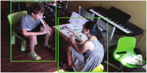 Child and adult sitting together at a table, playing the recorder (flute) 