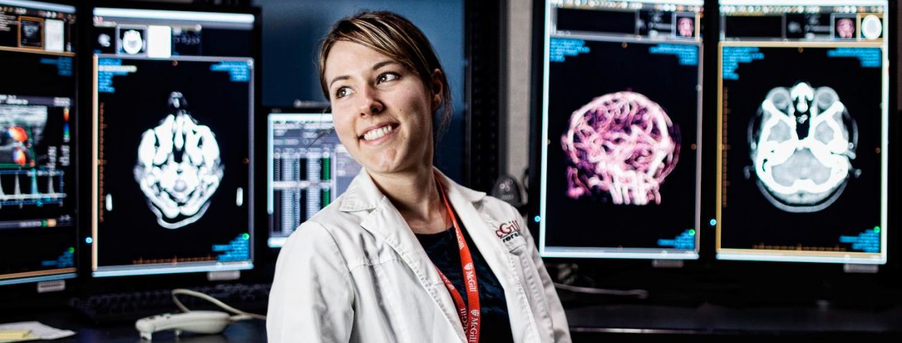 Female researcher sitting in front of images of brain scans
