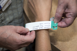 Patient putting on green hospital bracelet