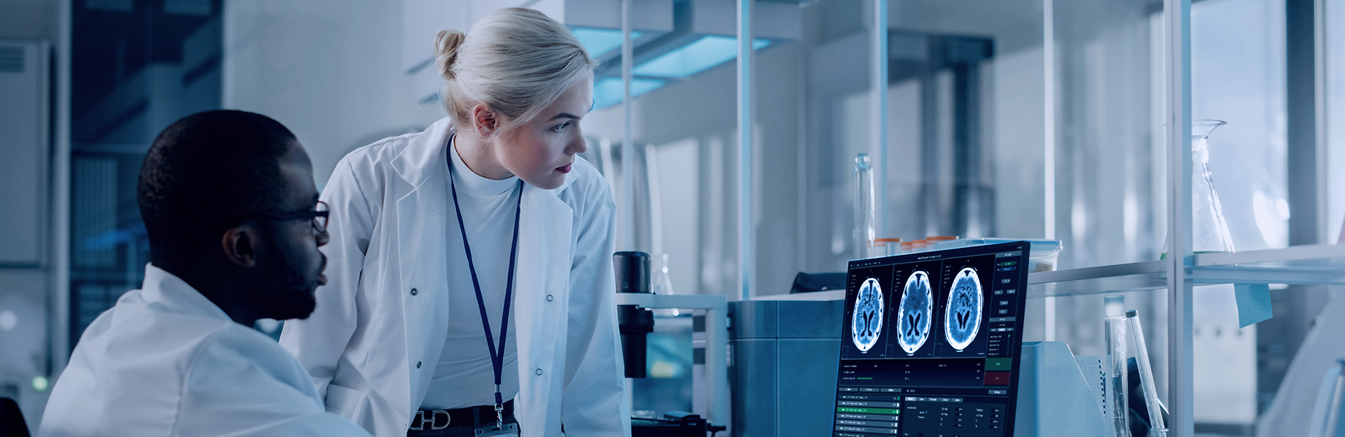 Two scientists looking at x-ray images on a computer screen in a lab