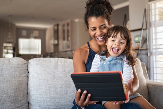 Parent et enfant lisant sur une tablette.