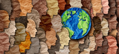 Cutouts of heads with different skin tones surrounding a map of the world
