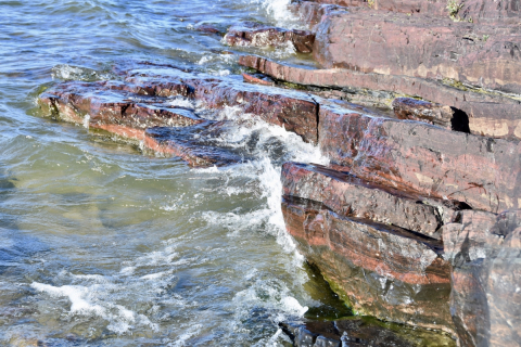 Ironstones deposited on the seafloor nearly two billion years ago now occur as rocky outcrops along the lakeshore of Tu Nedhé (Northwest Territories, Canada). Credit: Devon Cole / Des roches ferrugineuses qui se sont déposées sur le plancher océanique il y a près de deux milliards d’années prennent maintenant la forme d’un affleurement rocheux sur les rives du lac Tu Nedhé (Territoires du Nord-Ouest, Canada). Photo : Devon Cole