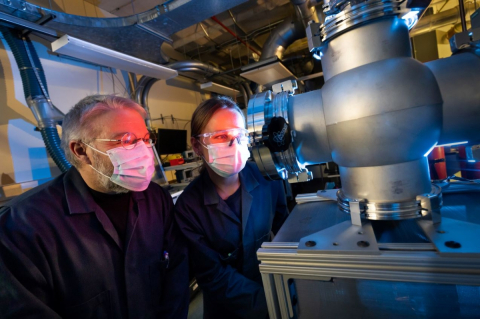 Professor Sylvain Coulombe and Lynn Hein examine a low pressure plasma system for the synthesis of advanced materials. Credit: Owen Egan