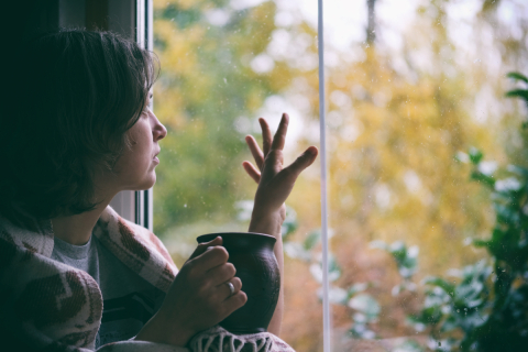 Woman looks out the window wistfully