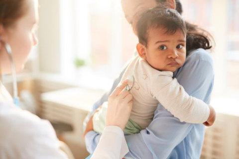Bébé dans les bras de sa mère qui se fait examiner par un médecin