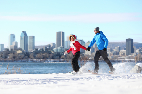 Two people cross-country skiing while holding hands.