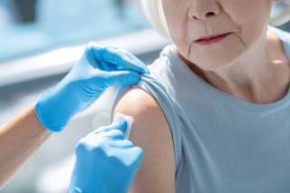 Elderly woman getting vaccinated. / Une femme âgée reçoit un vaccin.