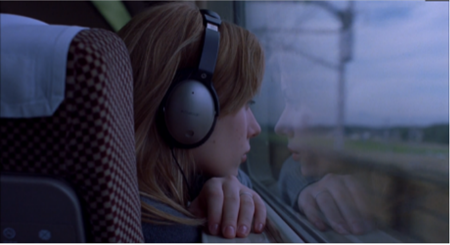 Woman looking out the window of a train.