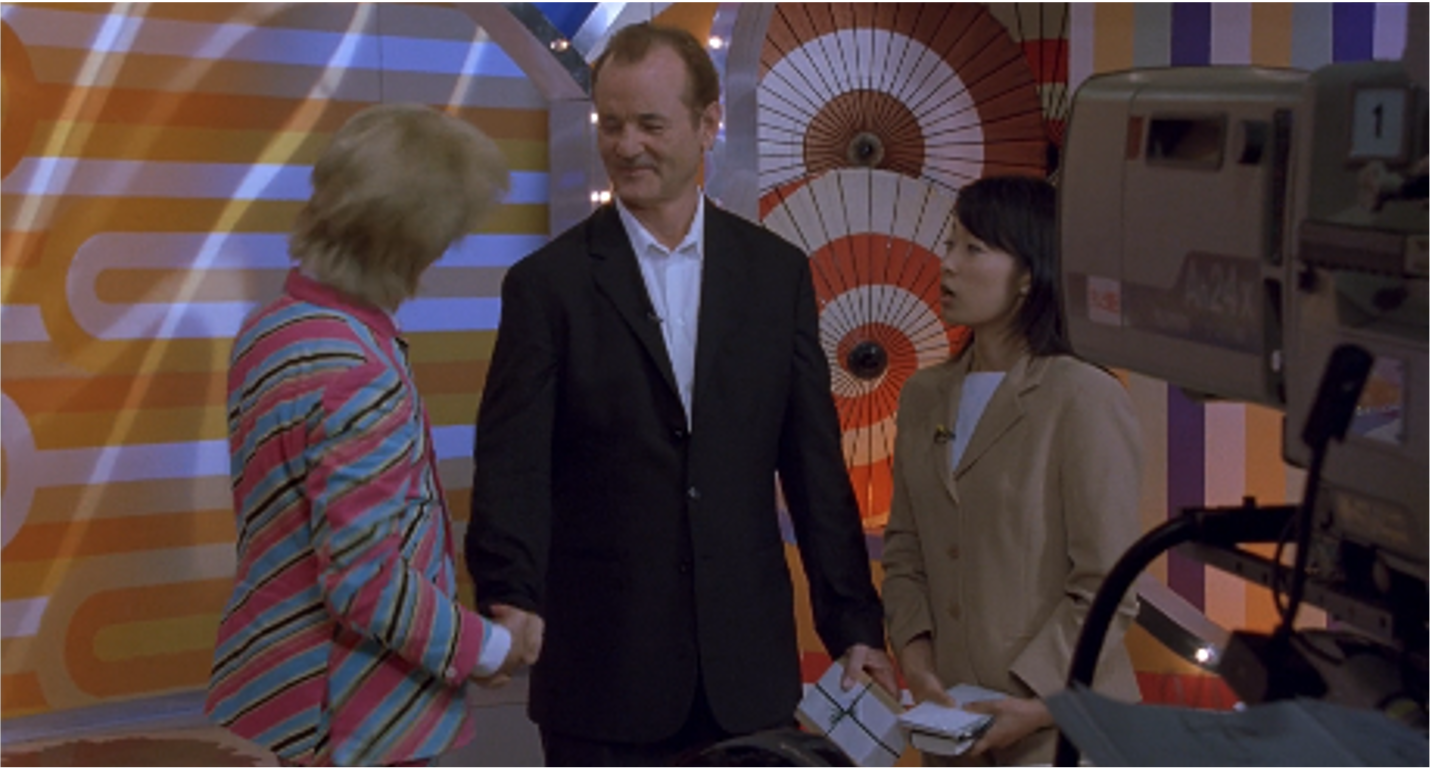 Man appearing on TV set with two TV hosts.