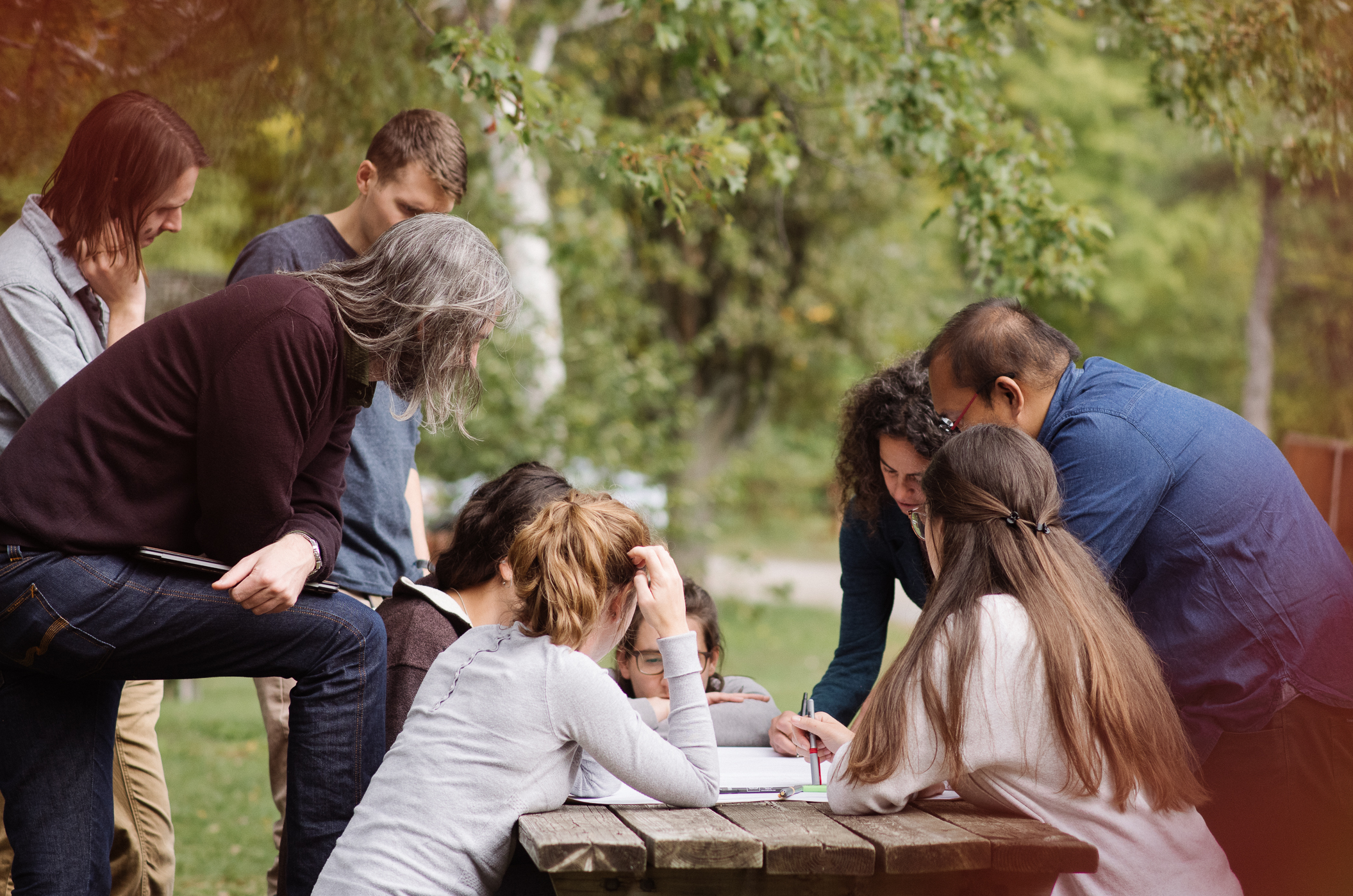graduate students and a professor gathered around a picnic table