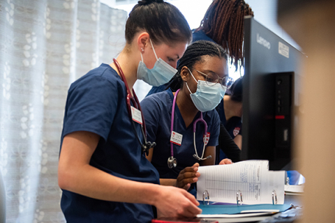 Deux étudiantes en sciences infirmières consultent des dossiers en milieu clinique