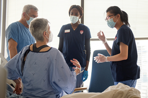 Deux étudiantes en sciences infirmières discutent avec un médecin et une patiente en milieu clinique