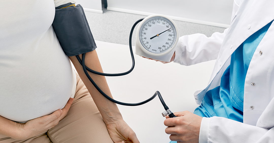 Pregnant woman has her blood pressure checked by her doctor