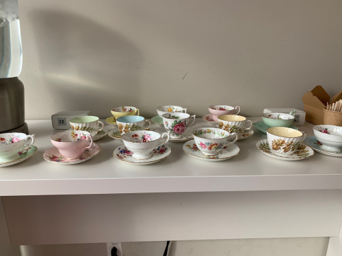 Close to two dozen China teacups with matching saucers are lined up on the counter at Homecoming 2023.