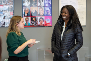 Two students in conversation during a break at the Graduate Student Symposiym.