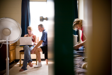 students looking a a laptop by a window