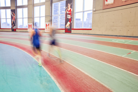 two students running at thomlinson field house
