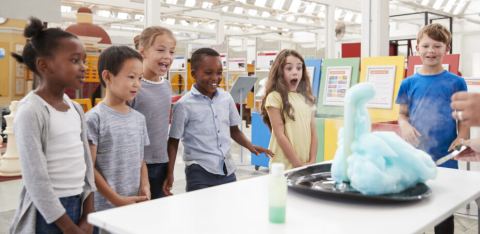 Kids look on in excitement at a science experiment