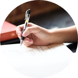 Hand holding a pen about to write on a piece of lined paper